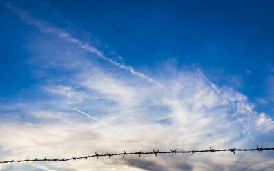 Clouds at dusk with barbed wire in foreground - HUSF00319