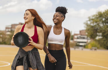 Glückliche Freunde beim Basketball auf dem Sportplatz - JCCMF07884