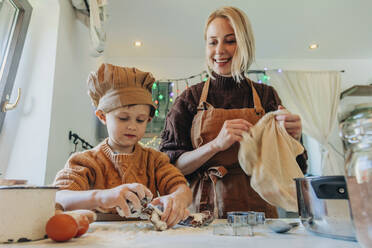 Happy mother and son preparing cookies at home - VSNF00114