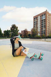 Young woman wearing roller skates at sports court - MEUF08522
