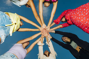 Happy female friends stacking hands at dusk - MEUF08545