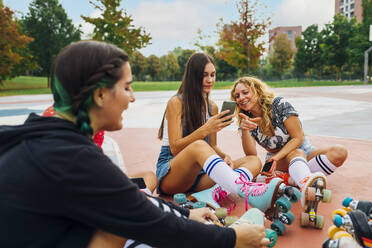 Frau teilt Smartphone mit Freund auf Sportplatz - MEUF08569