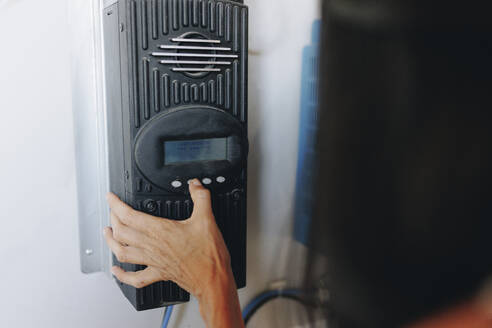 Hands of woman using solar charge controller - MRRF02507