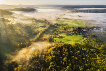 Deutschland, Baden-Württemberg, Drohnenansicht des in dichten Herbstnebel gehüllten Wieslauftals in der Morgendämmerung - STSF03670