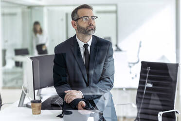 Kontemplativer Geschäftsmann mit Tablet-PC im Büro sitzend - JSRF02258