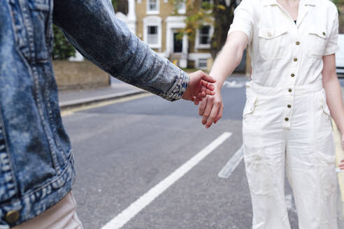 Frau gibt einem Freund auf der Straße die Hand - ASGF03089