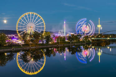 Deutschland, Baden-Württemberg, Stuttgart, Glühende Fahrgeschäfte auf dem nächtlichen Flussuferfestplatz - WDF07134