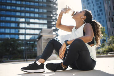 Durstige Frau trinkt Wasser an einem sonnigen Tag - JSRF02292