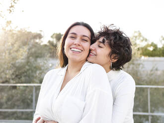 Romantic lesbian couple wearing white clothes enjoying together - AMRF00157