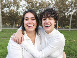 Junge glückliche lesbische Frauen, die sich im Park miteinander vergnügen - AMRF00161