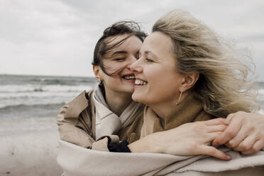 Happy daughter spending leisure time with mother at beach - VIVF00188