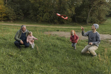 Family enjoying together playing with model airplane on grass - VIVF00223