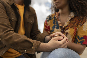Young couple holding hands and consoling each other - JCCMF07999
