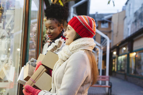 Frauen mit Geschenken beim Schaufensterbummel auf dem Weihnachtsfest - OSF01135