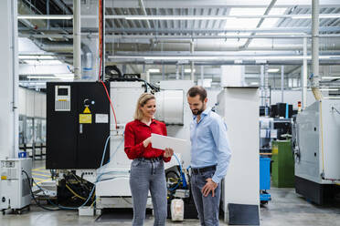 Geschäftskollegen diskutieren in der Fabrik über Tablet-PCs - DIGF19373