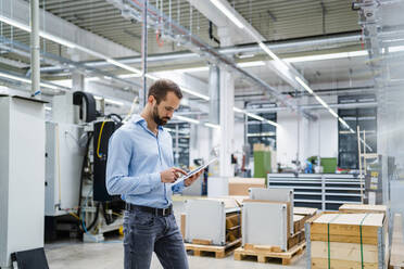 Businessman using tablet PC at factory - DIGF19394