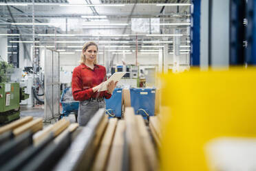 Businesswoman with tablet PC standing in industry - DIGF19457