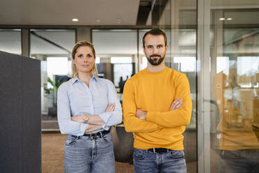 Confident business colleagues with arms crossed at office - DIGF19596