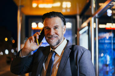 Smiling mature businessman talking on mobile phone - OIPF02731