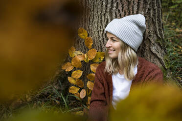 Lächelnde Frau mit Strickmütze im Herbstwald - HMEF01448