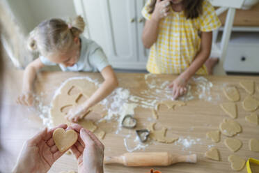 Hände einer Frau bei der Zubereitung von Keksen mit Mädchen zu Hause - SVKF00771