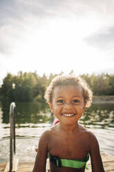 Porträt eines hemdlosen, fröhlichen Jungen am See - MASF32626