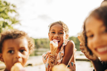 Glückliches Mädchen isst Eis mit Familie im Urlaub - MASF32635