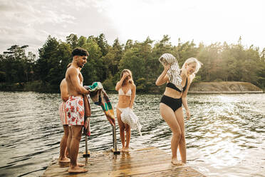 Männliche und weibliche Freunde genießen am See im Urlaub - MASF32647