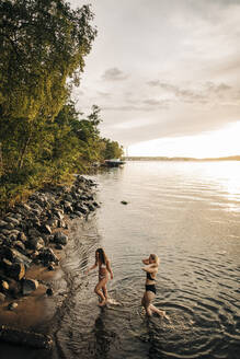 Hohe Winkel Ansicht der weiblichen Freunde genießen Urlaub am See bei Sonnenuntergang - MASF32684
