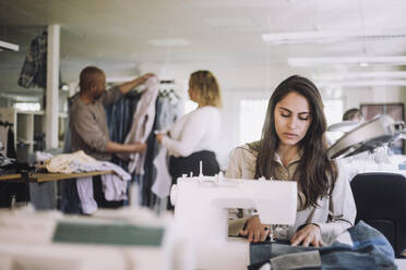 Designerin bei der Arbeit an der Nähmaschine in der Werkstatt - MASF32722