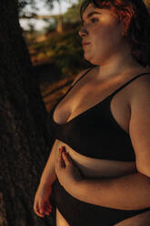 Nachdenkliche junge Frau in schwarzen Dessous bei Sonnenuntergang - MASF32896