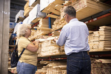 Male and female customers choosing plank at hardware store - MASF32930