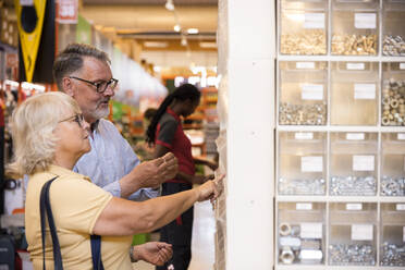 Senior male and female customers choosing merchandise at hardware store - MASF33021