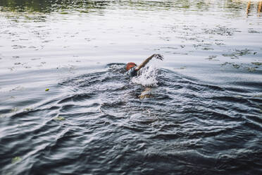Älterer Mann spritzt im Wasser, während er Freistilschwimmen im See übt - MASF33241