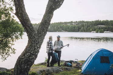 Älterer Mann im Gespräch mit einem Freund beim Camping am See - MASF33278