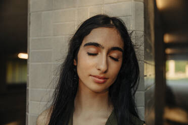 Teenager-Mädchen mit geschlossenen Augen gegen Säule - MASF33368