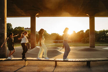 In voller Länge von Teenager-Mädchen zu Fuß auf der Bank unter der Brücke bei Sonnenuntergang - MASF33390