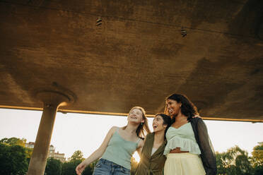 Fröhliche Freundinnen im Teenageralter, die sich unter einer Brücke vergnügen - MASF33395