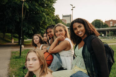 Porträt von Mädchen im Teenageralter, die zusammen im Park sitzen - MASF33432