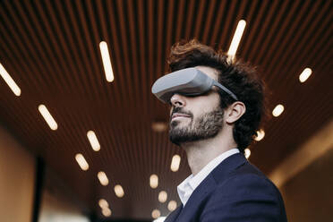Geschäftsmann mit Haarstoppeln trägt Virtual-Reality-Headset - EBBF07075