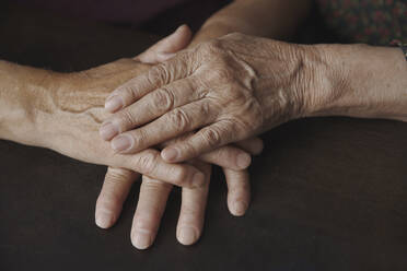 Couple with wrinkled hands on table - AZF00480