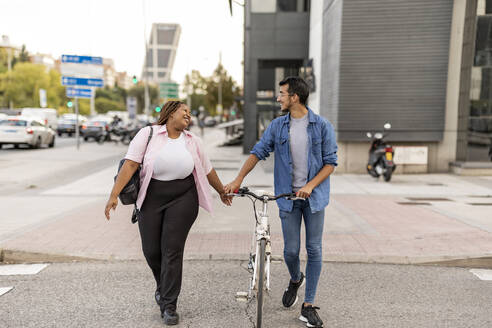 Glückliche Frau und Mann mit Fahrrad auf der Straße - JCCMF08110