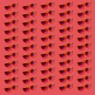 Muster einer altmodischen Sonnenbrille flach auf rotem Hintergrund - GIOF15640