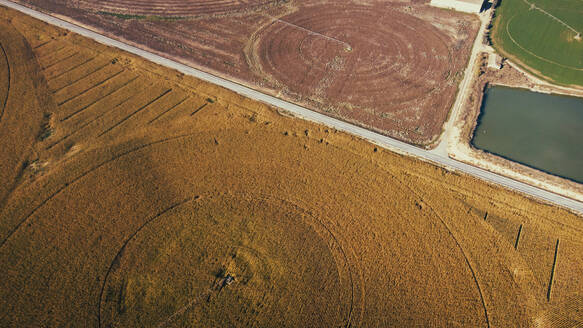 Spanien, Aragonien, Huesca, Luftaufnahme einer Landstraße, die sich durch trockene Maisfelder zieht - ACPF01539