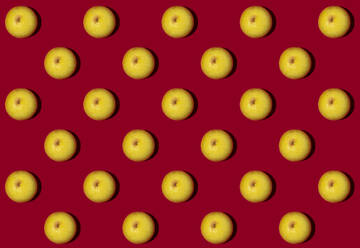 Pattern of halved lemons flat laid against red background - GIOF15646