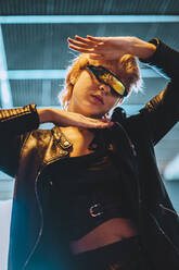 Woman wearing smart glasses gesturing in underpass - IFRF01885