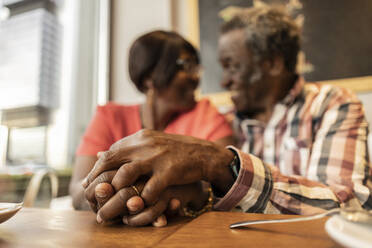 Romantisches älteres Paar mit ineinander verschlungenen Händen im Cafe - JCCMF08252