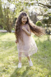 Cheerful girl running on grass in park - ONAF00270