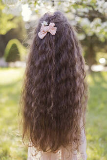 Mädchen mit langen gewellten Haaren und rosa Schleife - ONAF00272