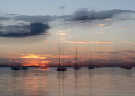 Germany, Baden-Wurttemberg, Allensbach, Sailboats moored in harbor on shore of Lake Constance at sunset - BSTF00219